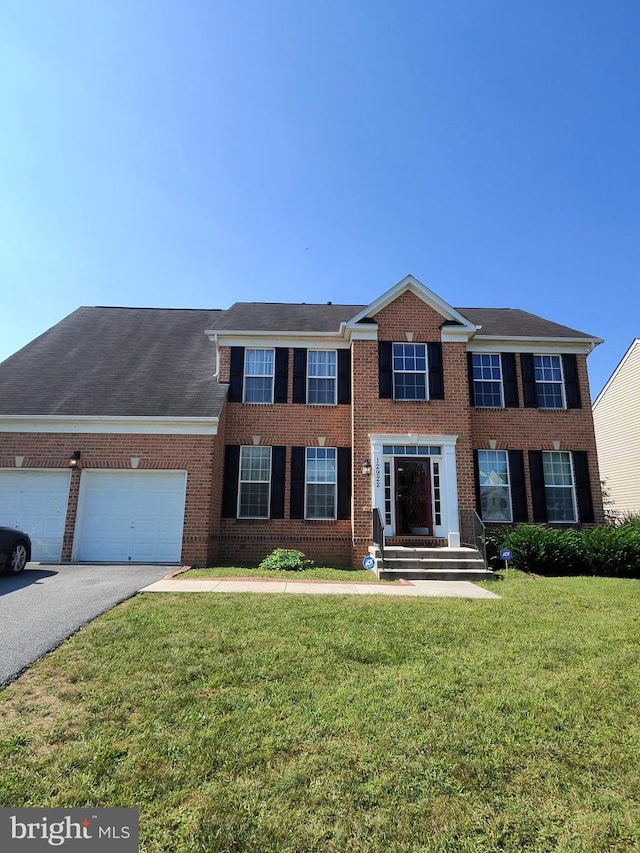 view of front of property featuring a front yard and a garage