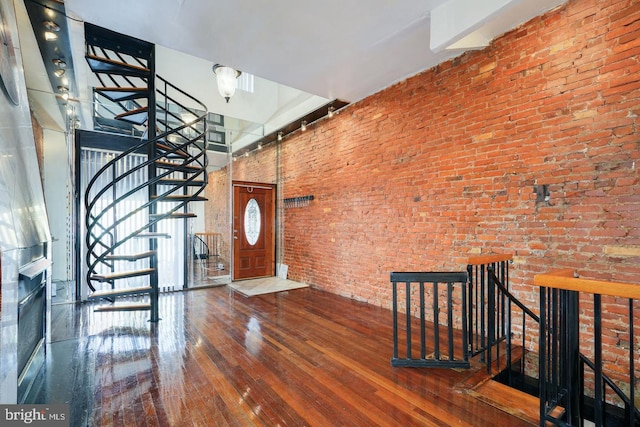 entryway featuring brick wall and hardwood / wood-style floors