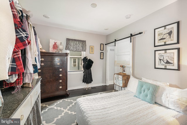 bedroom featuring dark hardwood / wood-style floors and a barn door