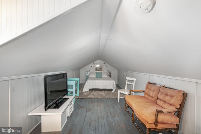 unfurnished bedroom with vaulted ceiling, wood walls, and dark wood-type flooring