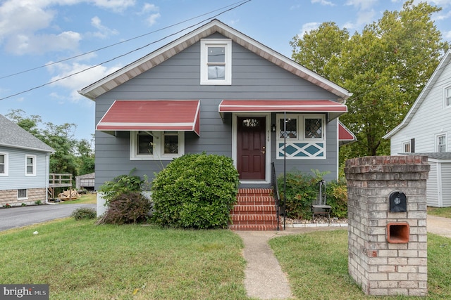 bungalow-style home with a front yard