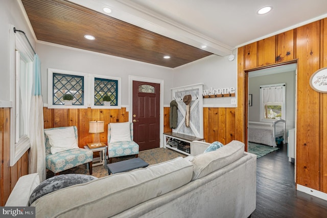 living room with ornamental molding, wooden walls, and dark hardwood / wood-style floors