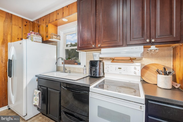 kitchen featuring backsplash, wooden walls, white appliances, and sink