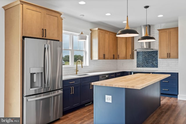 kitchen featuring stainless steel fridge, hanging light fixtures, a kitchen island, sink, and butcher block countertops