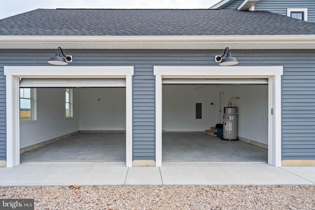 garage featuring wood walls, water heater, and electric panel