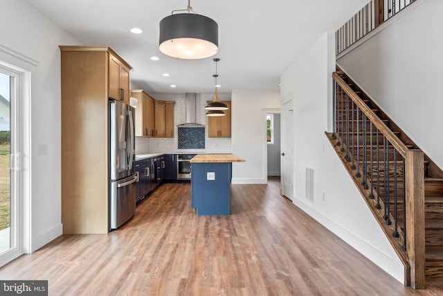 kitchen with a wealth of natural light, appliances with stainless steel finishes, a center island, and pendant lighting