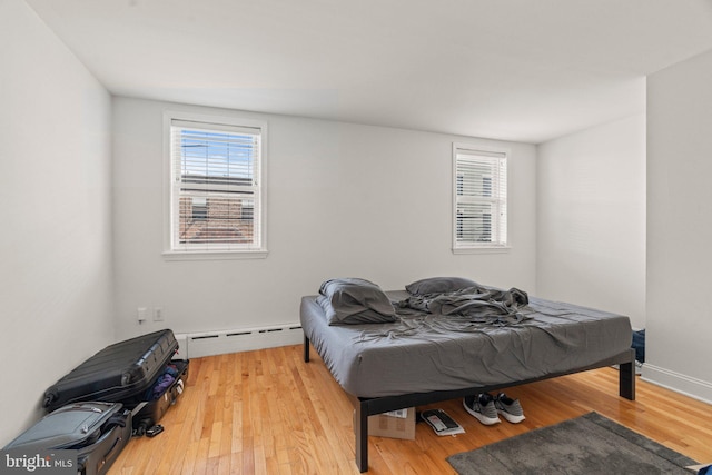 bedroom featuring light wood-type flooring and baseboard heating