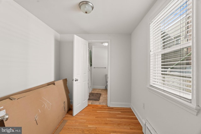 hall with a baseboard radiator and light wood-type flooring