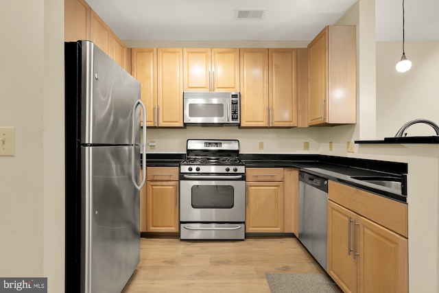 kitchen with light hardwood / wood-style floors, light brown cabinetry, stainless steel appliances, and decorative light fixtures