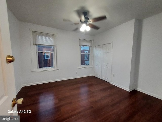 spare room featuring ceiling fan and dark wood-type flooring