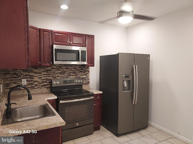 kitchen with tasteful backsplash, sink, light tile patterned flooring, and stainless steel appliances