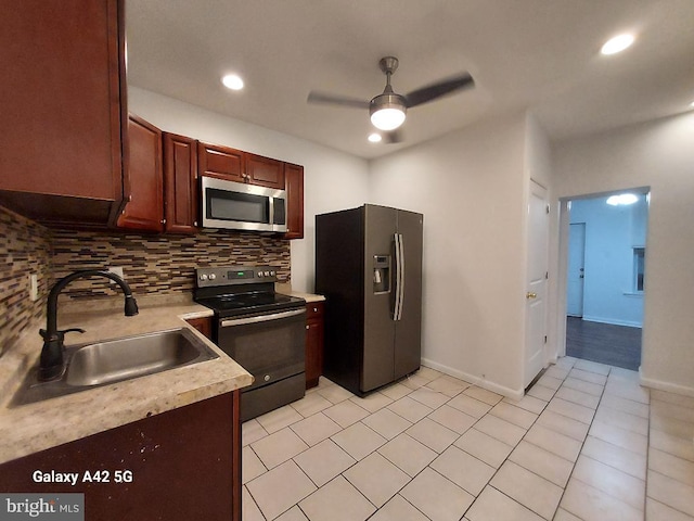 kitchen featuring backsplash, stainless steel appliances, ceiling fan, and sink