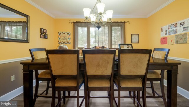 dining area with an inviting chandelier, dark wood-type flooring, and crown molding