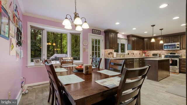 dining area with crown molding, light hardwood / wood-style floors, sink, and a notable chandelier