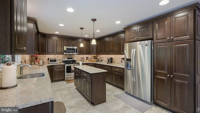 kitchen featuring hanging light fixtures, sink, a kitchen island, dark brown cabinets, and stainless steel appliances