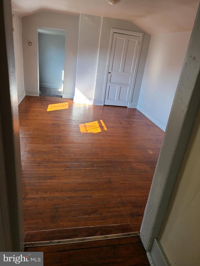 spare room featuring lofted ceiling and dark hardwood / wood-style flooring