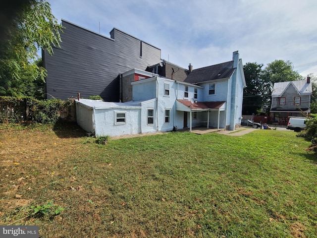 rear view of property with a yard and a patio area