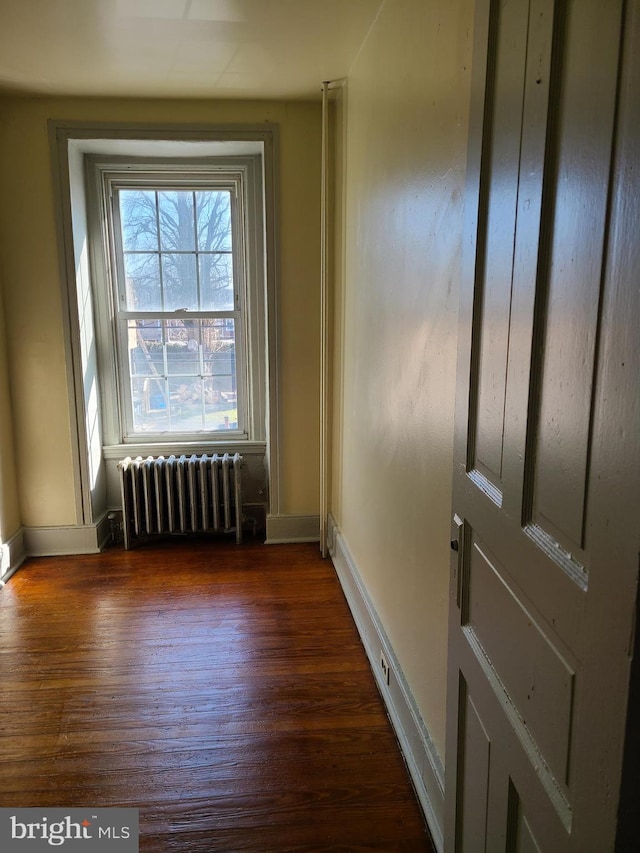 interior space featuring dark wood-type flooring and radiator heating unit