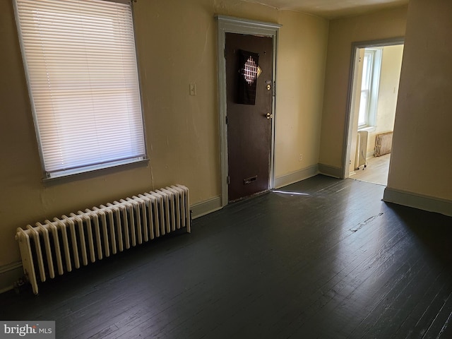 entrance foyer with radiator heating unit and wood-type flooring