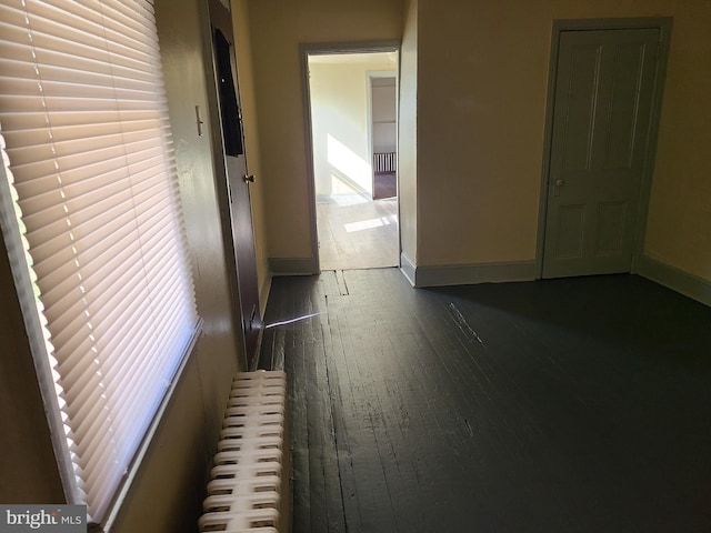 hall with radiator and dark hardwood / wood-style floors