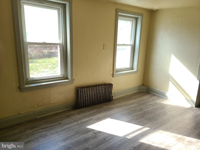 spare room featuring radiator and hardwood / wood-style flooring