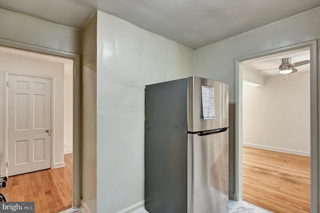 kitchen featuring ceiling fan, stainless steel refrigerator, and hardwood / wood-style flooring