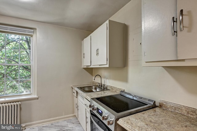 kitchen with radiator, sink, white cabinets, and stainless steel electric range