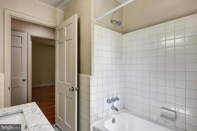 bathroom with vanity, hardwood / wood-style floors, and tiled shower / bath