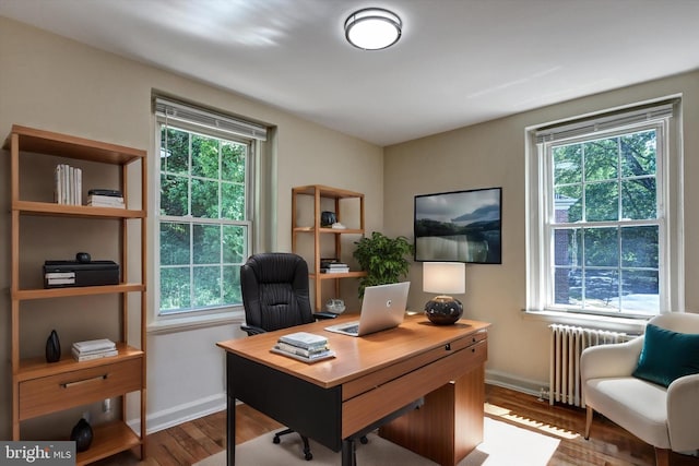 office with radiator heating unit, wood-type flooring, and plenty of natural light