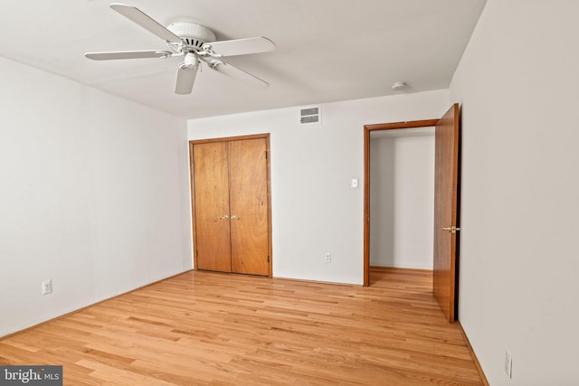 unfurnished bedroom with light hardwood / wood-style flooring, a closet, and ceiling fan