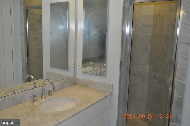 bathroom with walk in shower and vanity