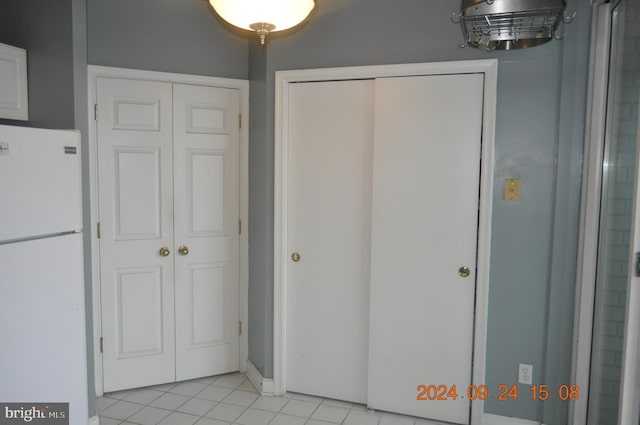 interior space with light tile patterned floors and white fridge