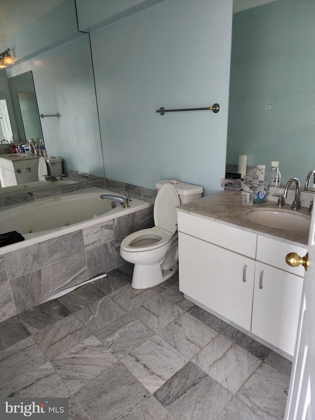 bathroom with vanity, tiled bath, and toilet