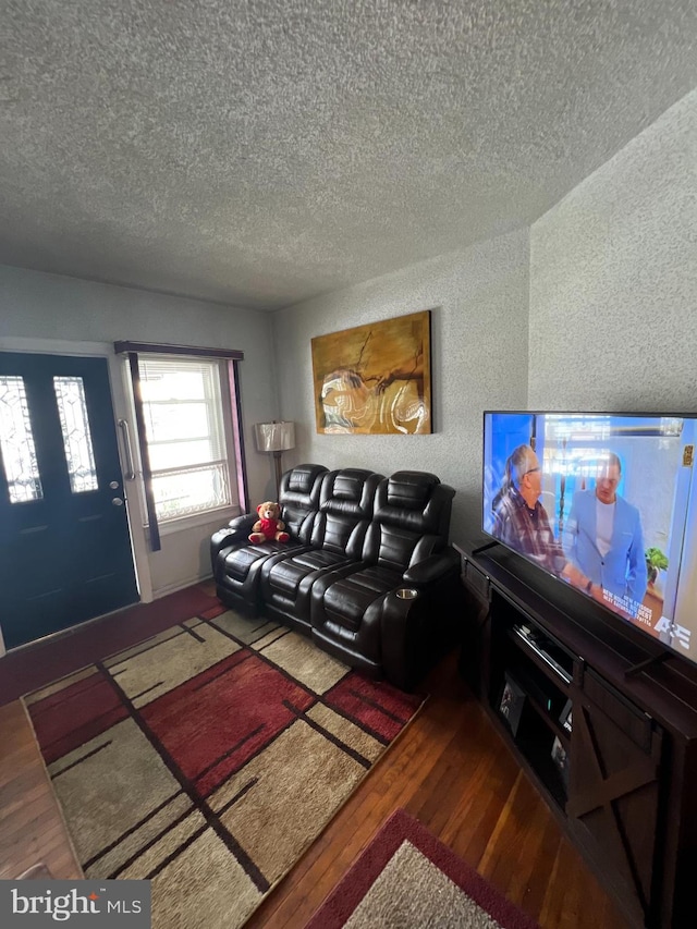 living room featuring a textured ceiling and dark hardwood / wood-style floors