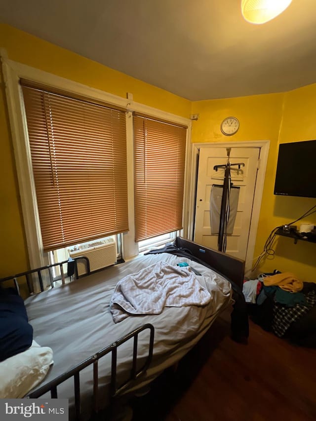 bedroom with cooling unit and hardwood / wood-style flooring