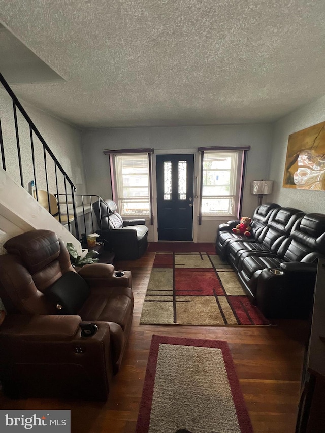 living room featuring a textured ceiling, plenty of natural light, and dark wood-type flooring