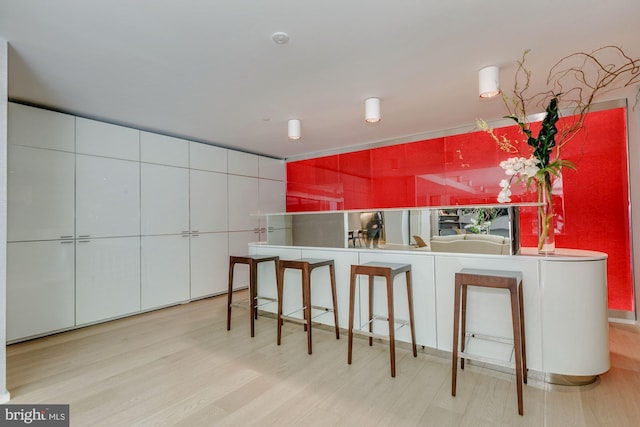 kitchen with light hardwood / wood-style flooring and white cabinets