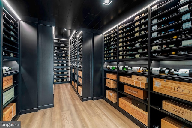 wine room with electric panel and light hardwood / wood-style floors