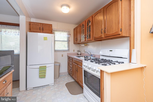 kitchen featuring crown molding, white appliances, and sink