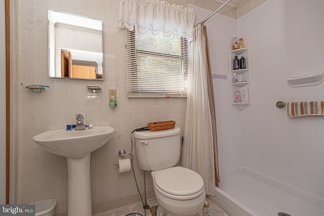 bathroom featuring tile walls, toilet, a shower with shower curtain, and tile patterned floors