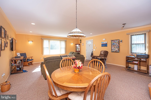 carpeted dining room with ornamental molding and a healthy amount of sunlight