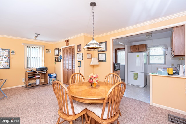 dining area featuring crown molding and light colored carpet