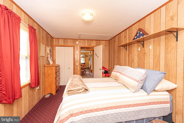 bedroom with ornamental molding, wood walls, and a textured ceiling