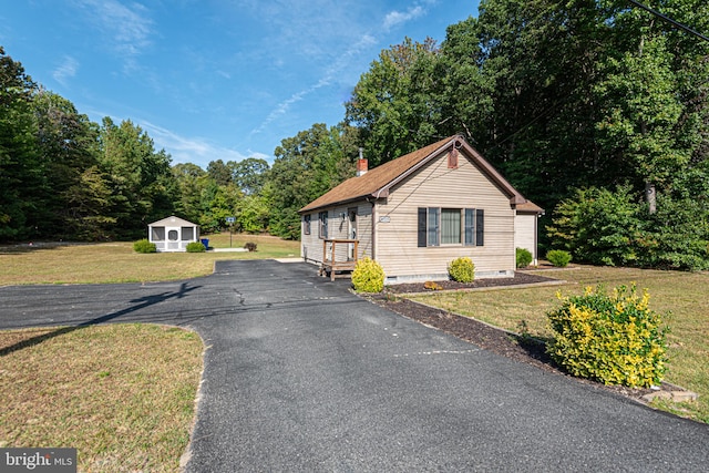 view of front of home featuring an outdoor structure and a front yard