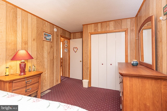 unfurnished bedroom with wooden walls, a closet, a textured ceiling, and crown molding