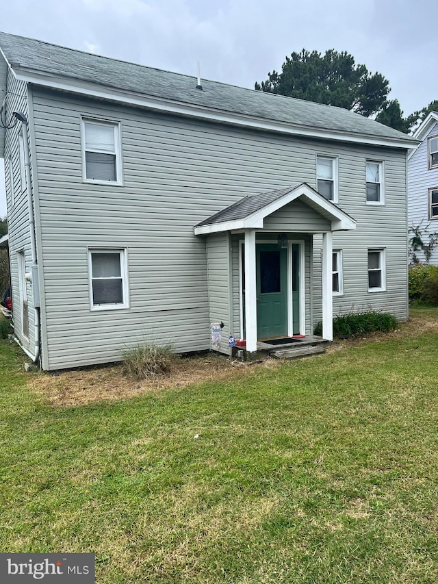 rear view of house featuring a lawn