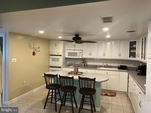 kitchen featuring ceiling fan, white cabinets, sink, white appliances, and backsplash