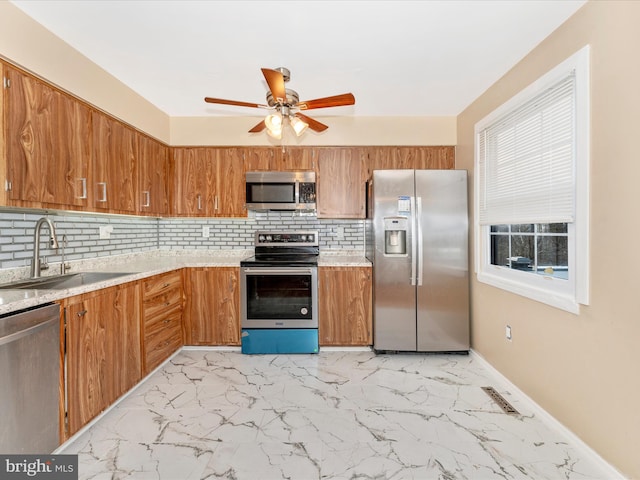 kitchen featuring backsplash, ceiling fan, sink, and appliances with stainless steel finishes