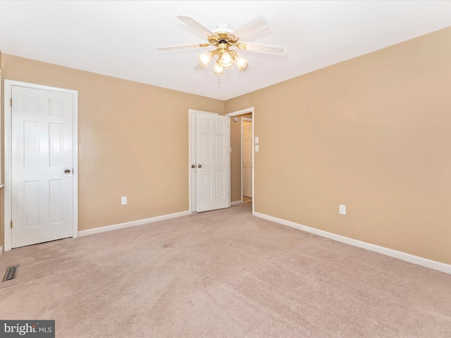 carpeted spare room featuring ceiling fan