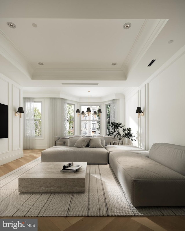 living room with crown molding, wood-type flooring, and a raised ceiling